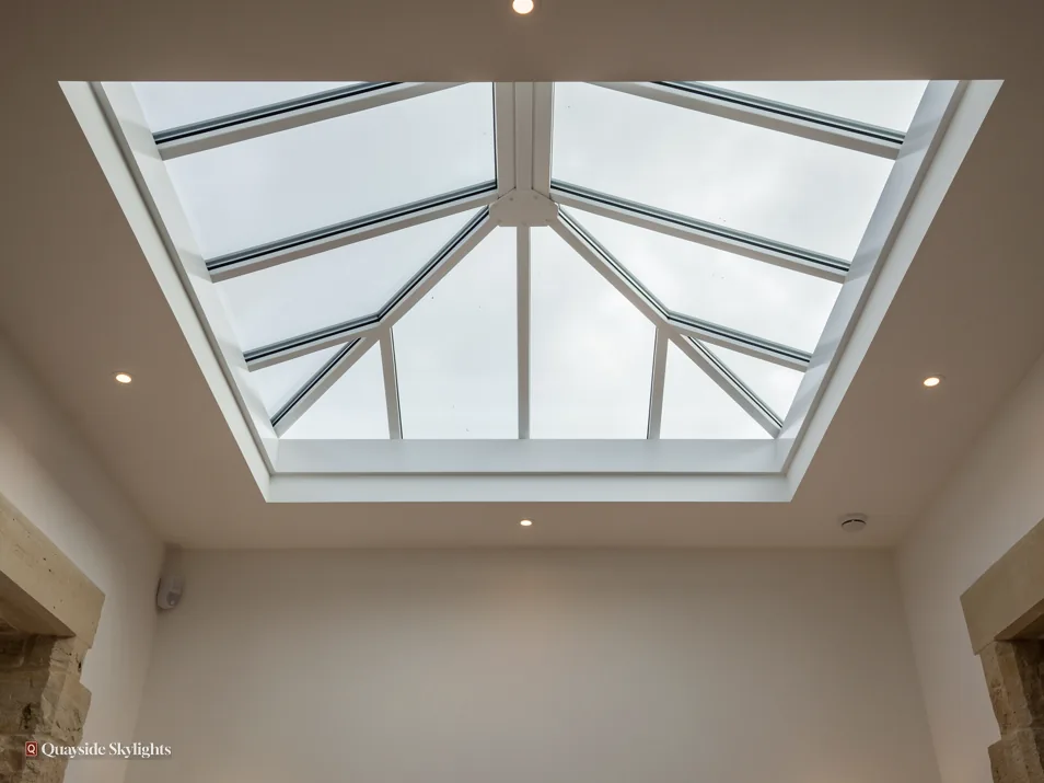 Hipped roof lantern seen from below in a white ceiling with downlights