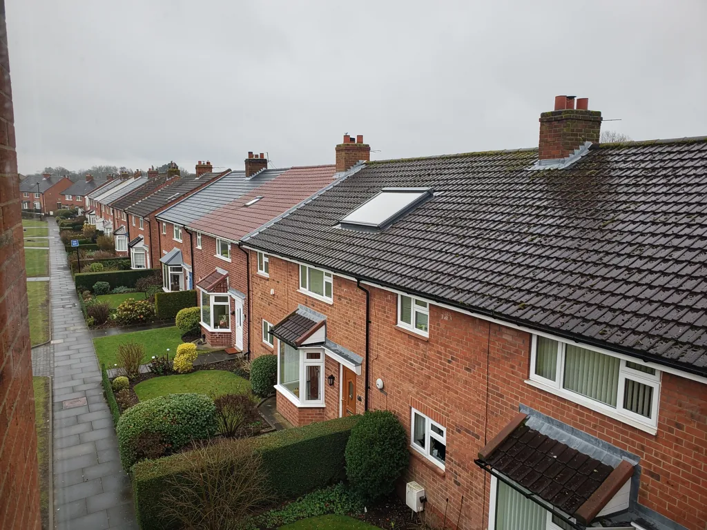 Brick semi-detached houses with front gardens and hedges seen from above