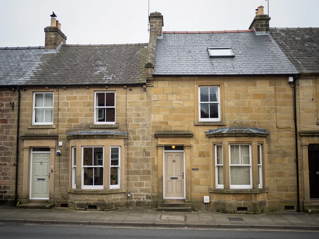 Sandstone terraced houses with bay windows and a slate roof with one roof window
