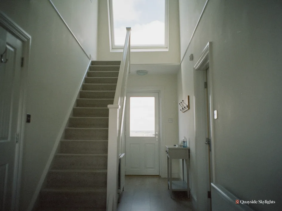 Hallway and staircase lit only by a single window at the top of the stairs