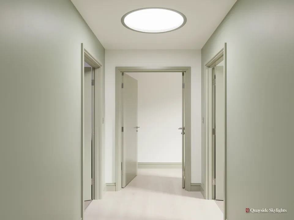 Pale green hallway with a round sun tunnel diffuser and open doors