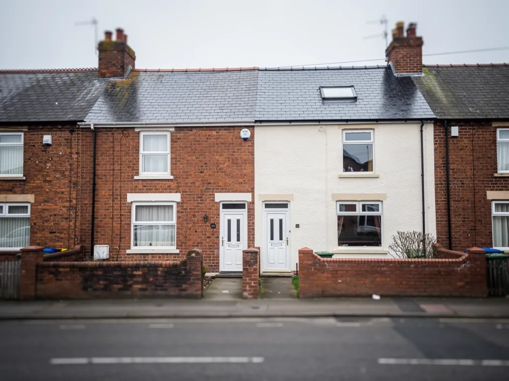 Brick and white-painted terraced houses facing a quiet street