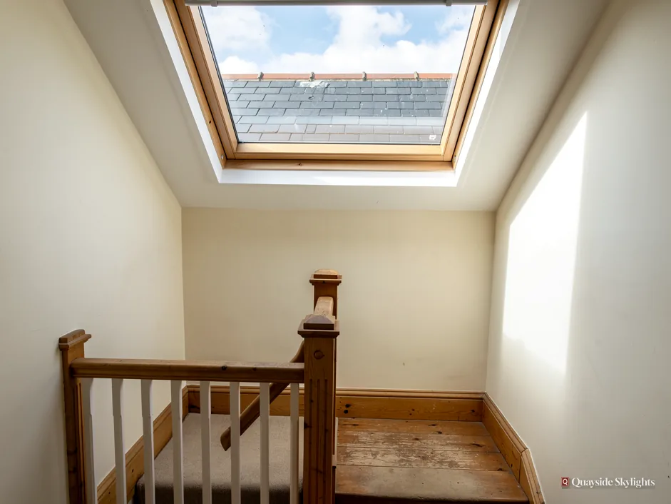 Stair landing with a timber newel post below a roof window