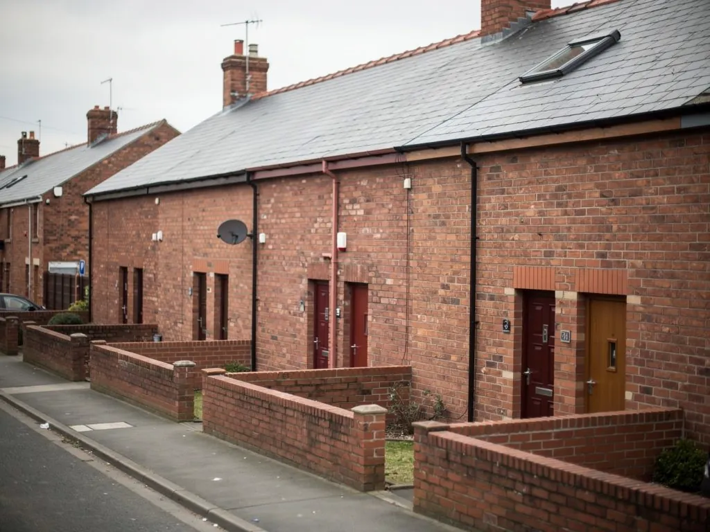 Brick terraced houses with walled front yards and a roof window