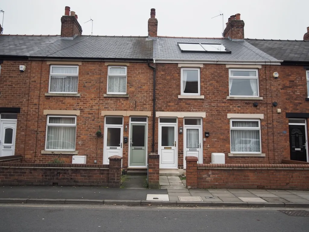 Red brick terraced street with a roof window and small front yards