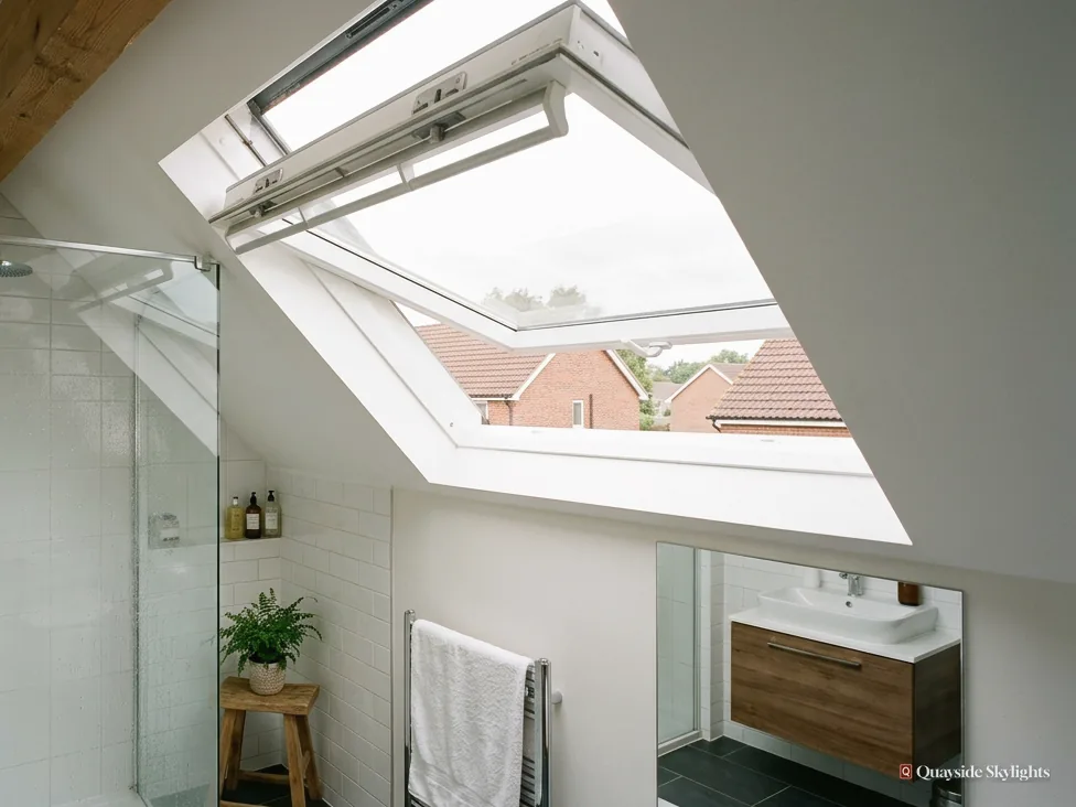 Shower room with an open roof window above a vanity unit and towel