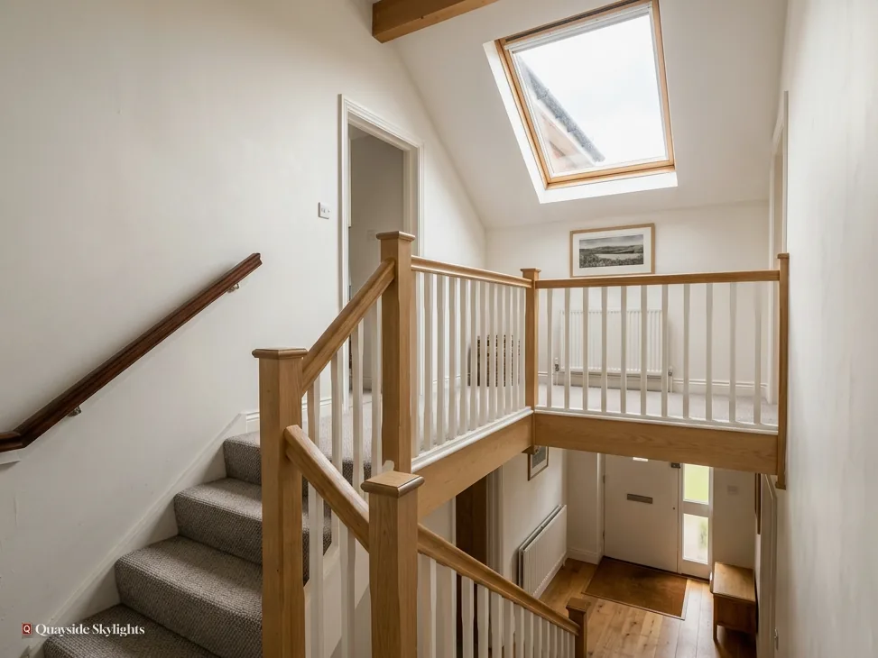 Landing and staircase with an oak balustrade under a roof window