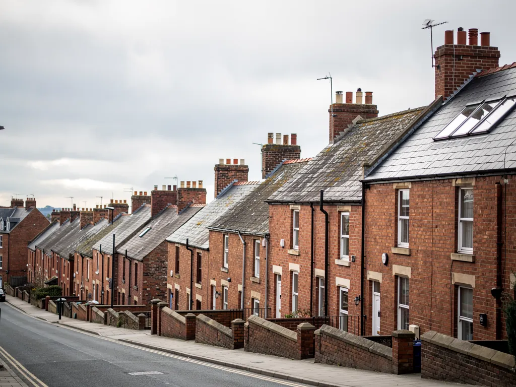 Brick terraces with chimneys and roof windows on a sloping street