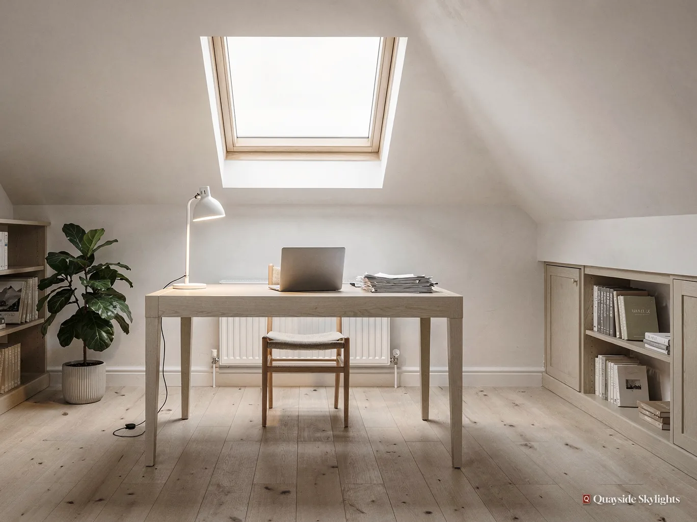 Loft study with a white desk, chair and lamp below a roof window