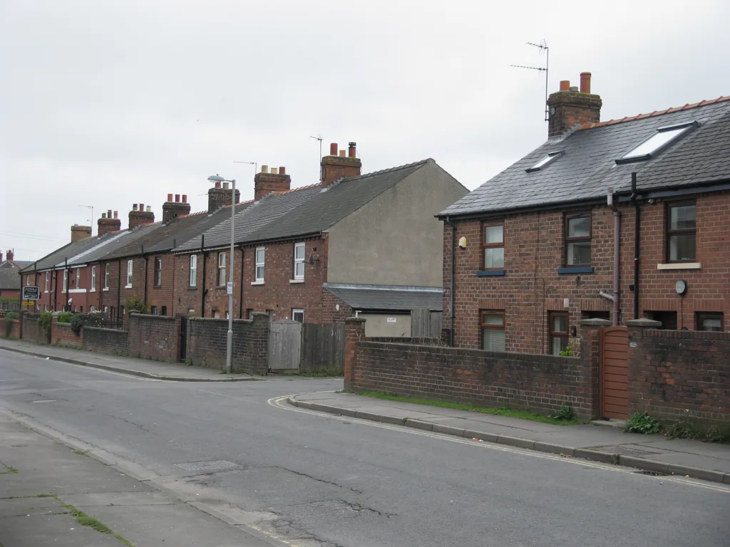 Brick terraced houses on a street corner with low front walls