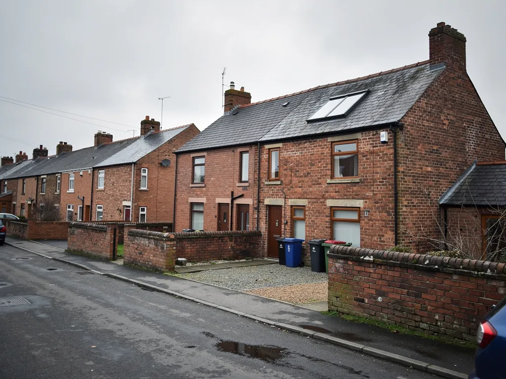 Brick terraced houses with roof windows on a quiet corner street