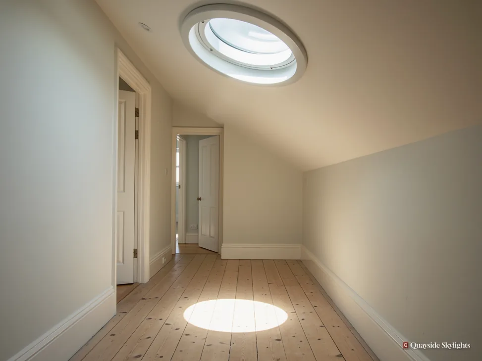 Empty room with a circular sun tunnel casting a pool of light on the floor