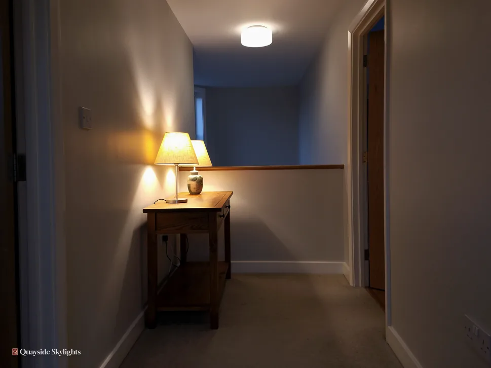 Dim landing with a lamp glowing on a small side table