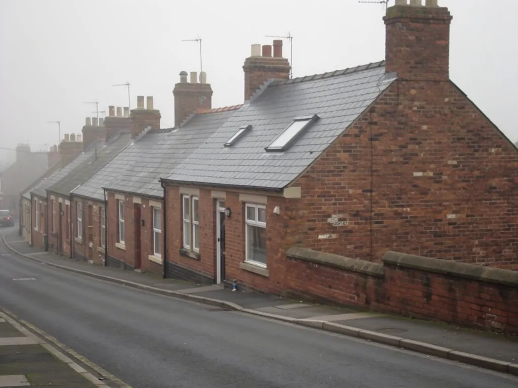 Brick terraces with roof windows on a misty sloping street