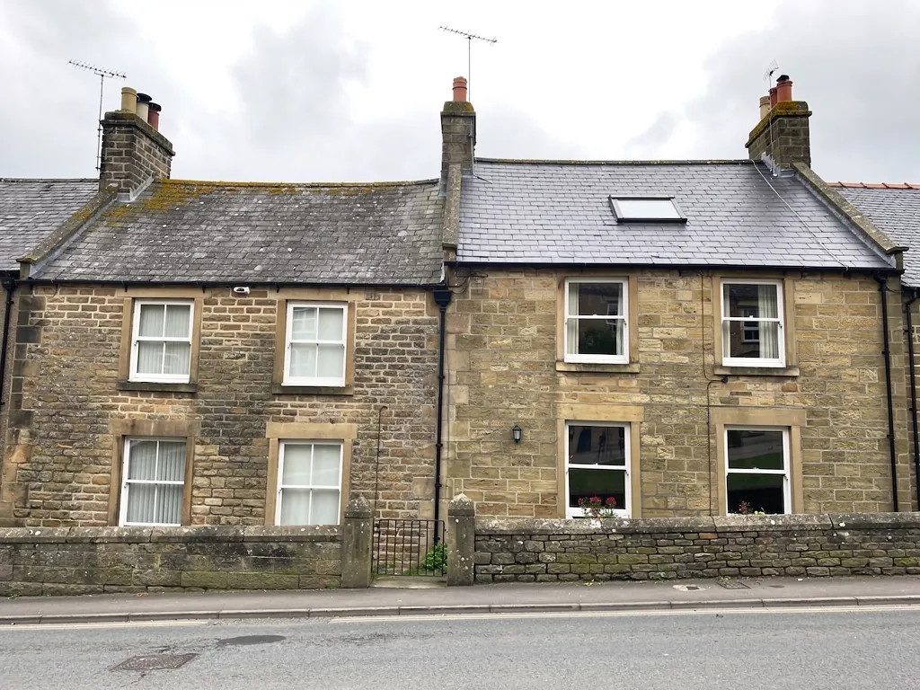 Sandstone terraced houses with sash windows and a roof window in the slate roof