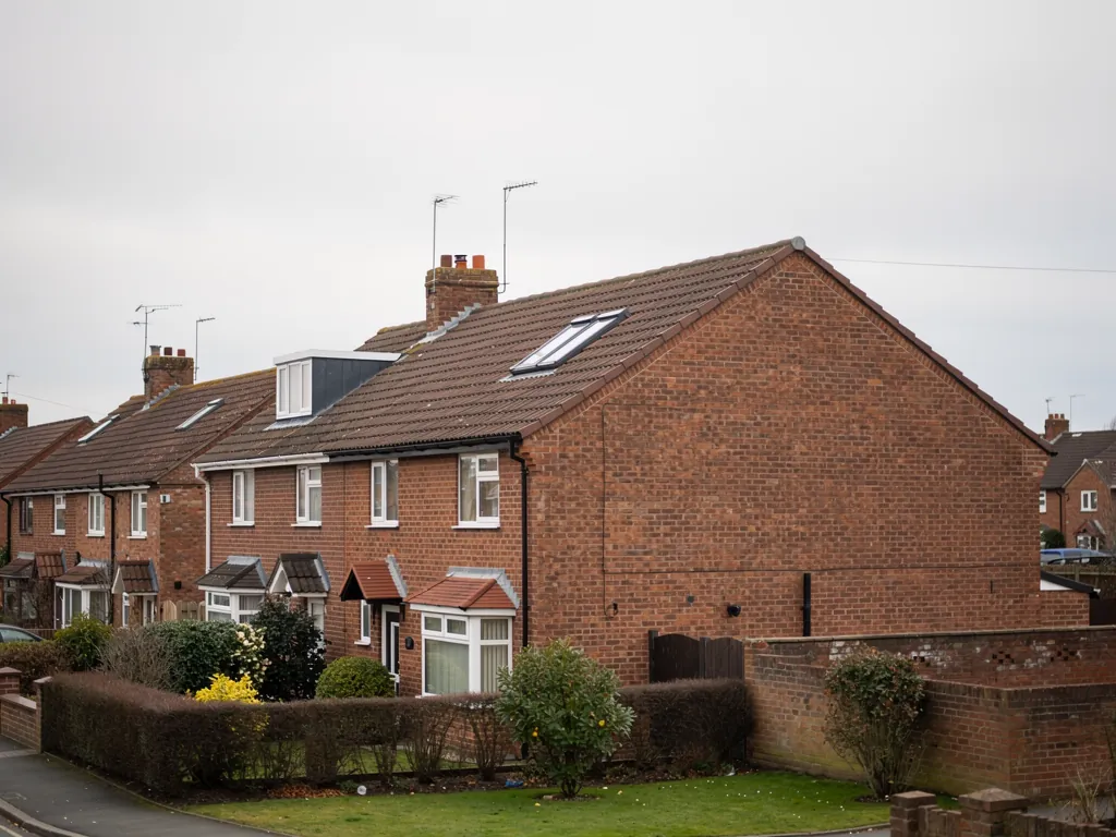Brick semi-detached houses with a roof window on a residential street