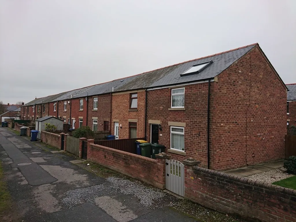 Back lane behind brick terraced houses with garden walls