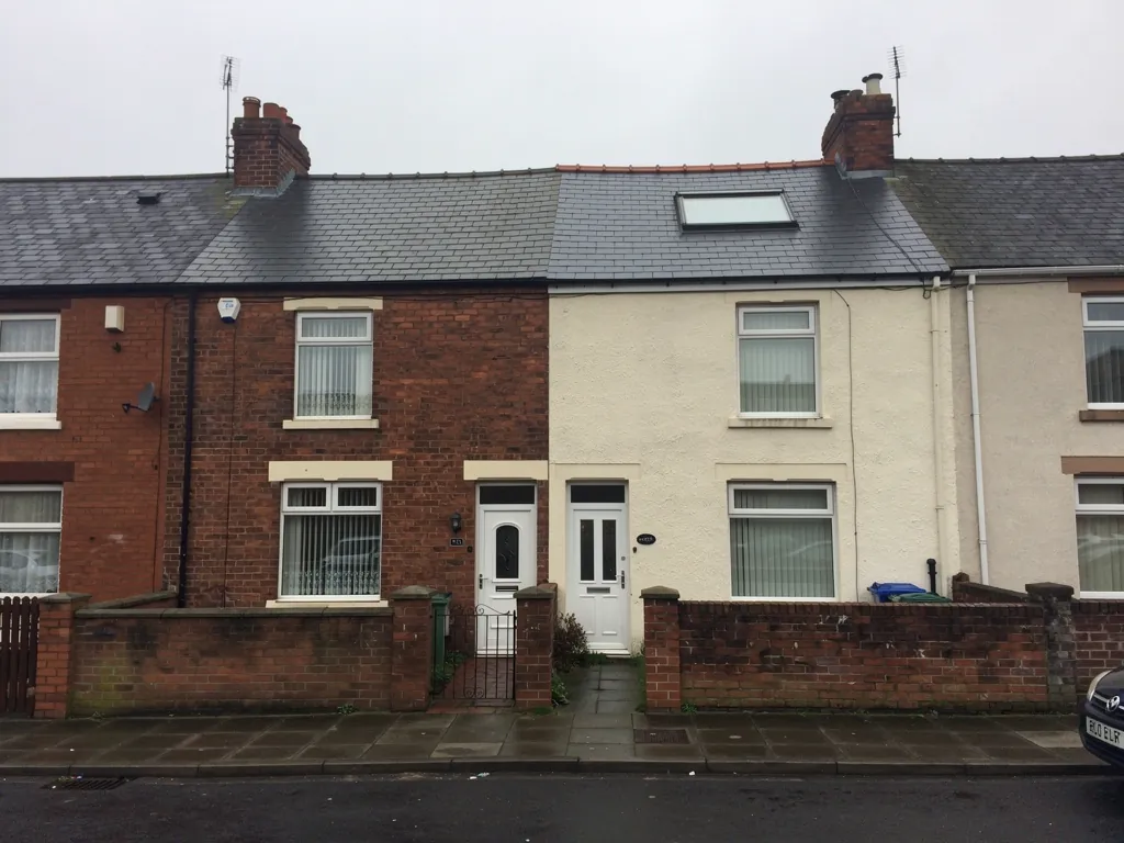 Brick and cream painted terraced fronts with a roof window