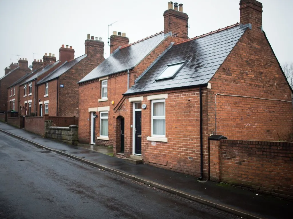 Brick terraced houses with a roof window on a wet street
