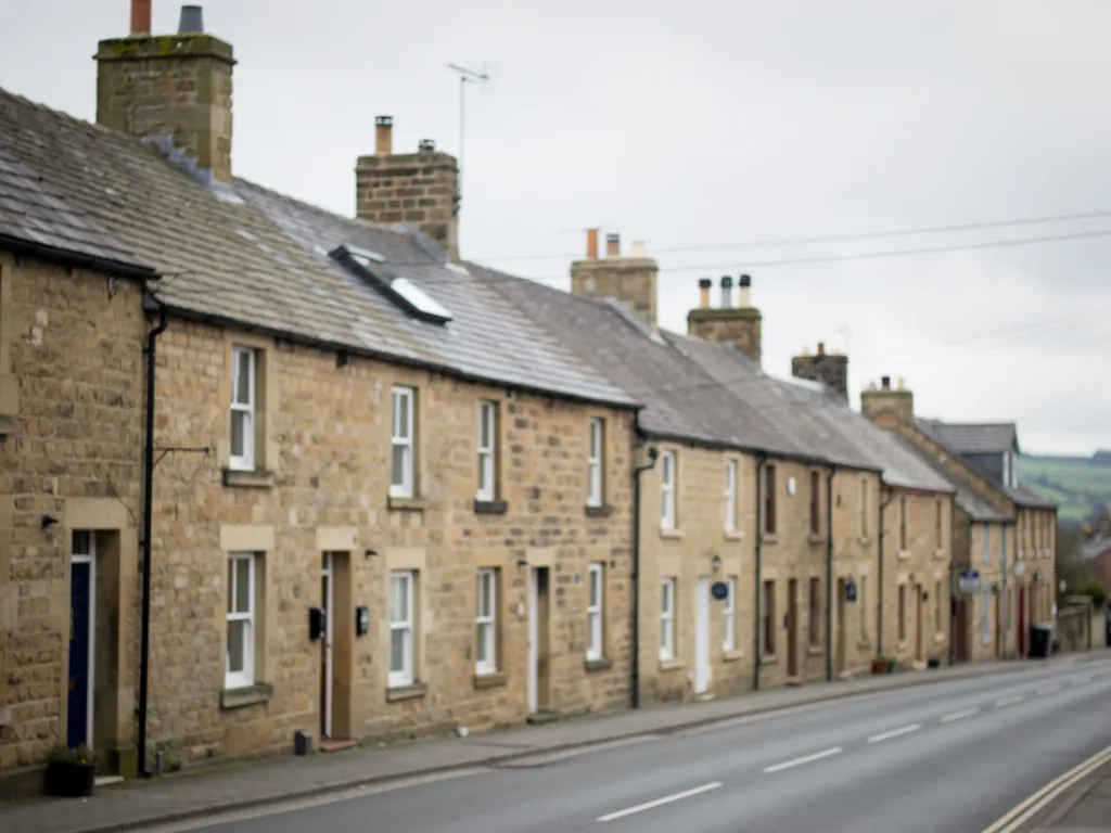 Sandstone terraced row with slate roofs along a main road