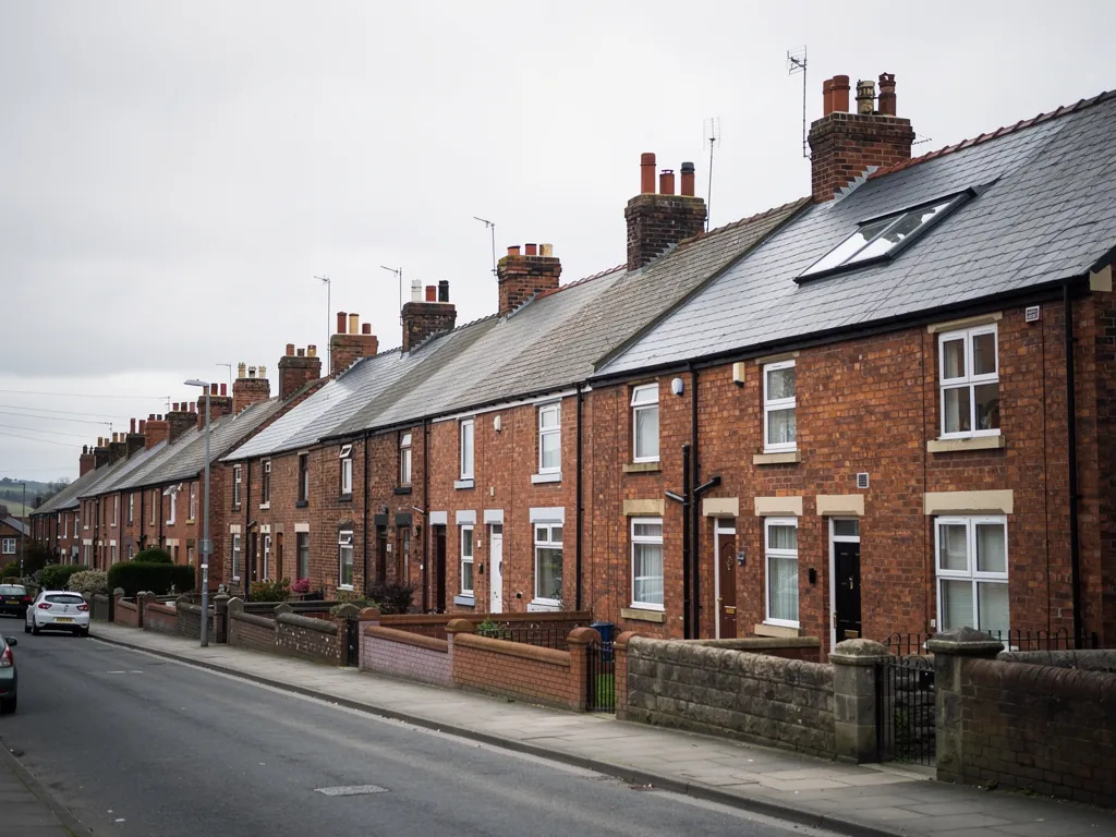Brick terraced houses with roof windows behind low front walls