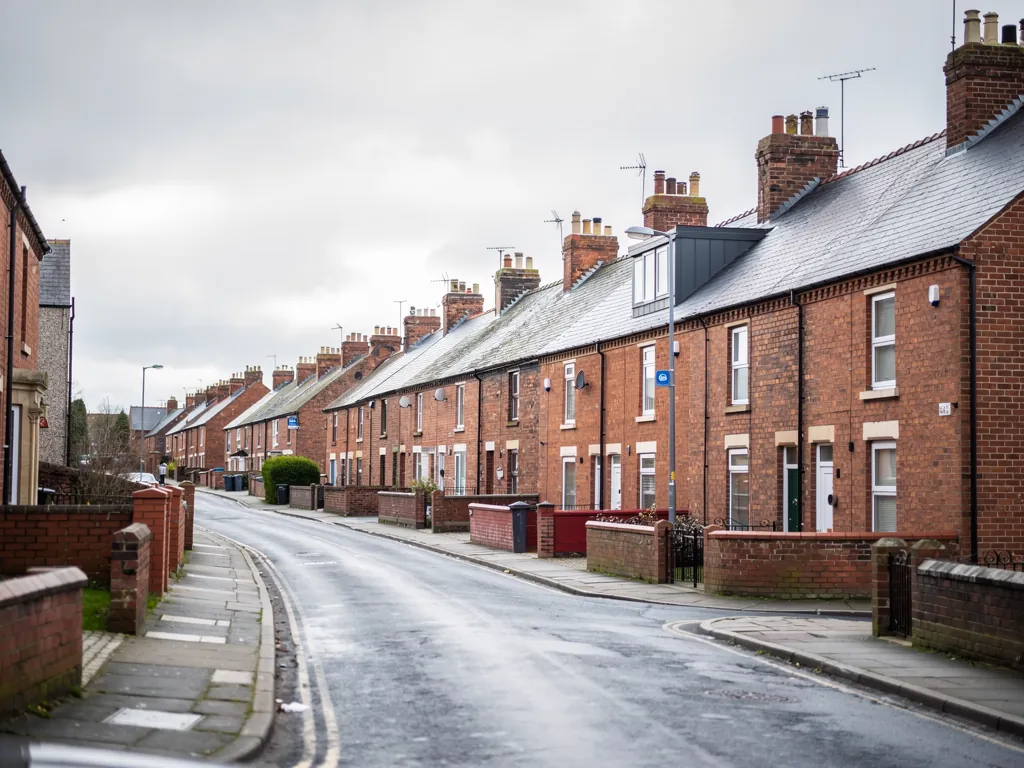 Brick terraced street curving downhill with dormers on the roofs
