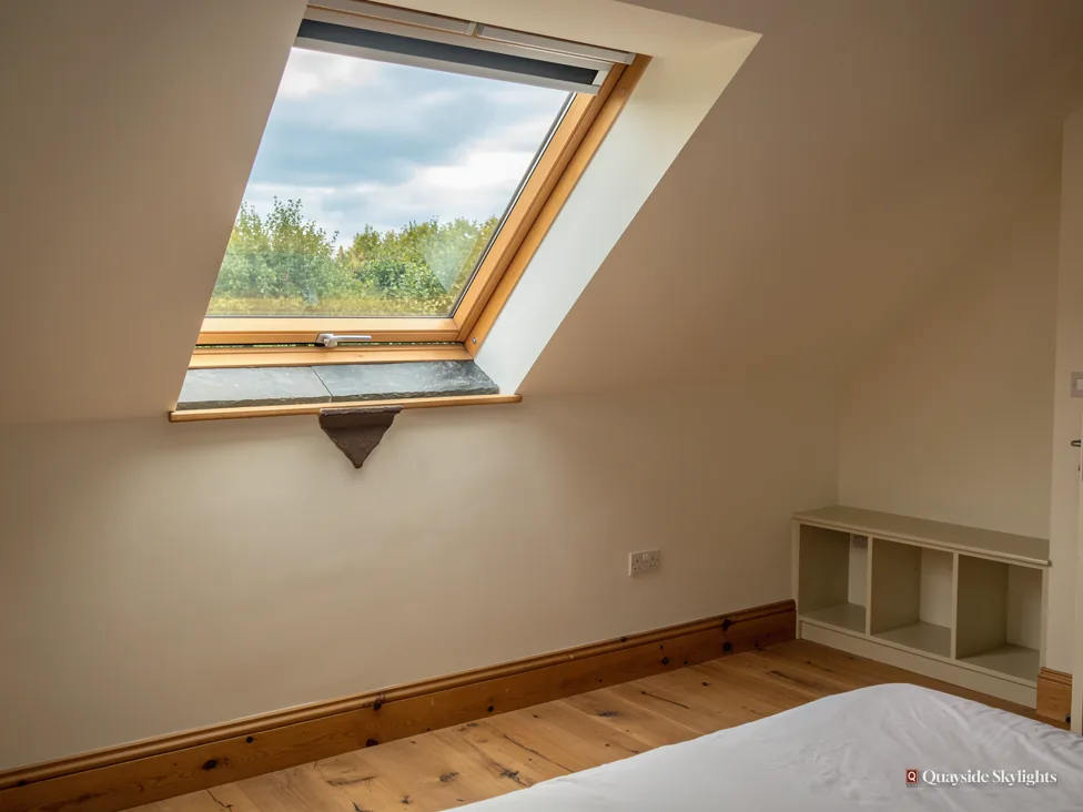 Room with a pine roof window open to trees and sky