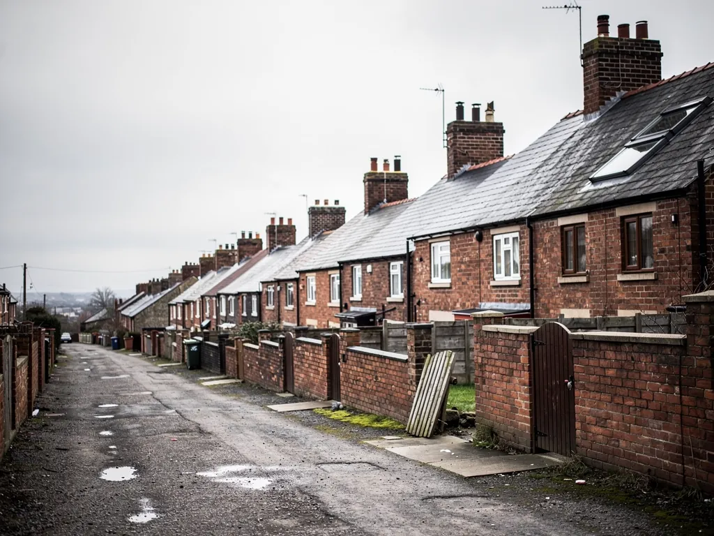 Back lane between brick terraces with yard walls and chimneys