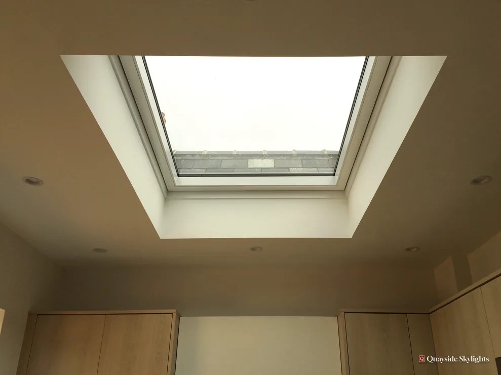 Rooflight in a deep ceiling well above fitted cupboards in a dim room