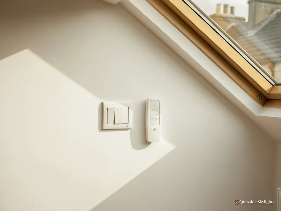 Wall switch and remote control mounted beside the edge of a roof window