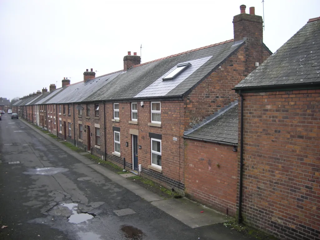 Long brick terrace row on a wet lane with a slate roof window